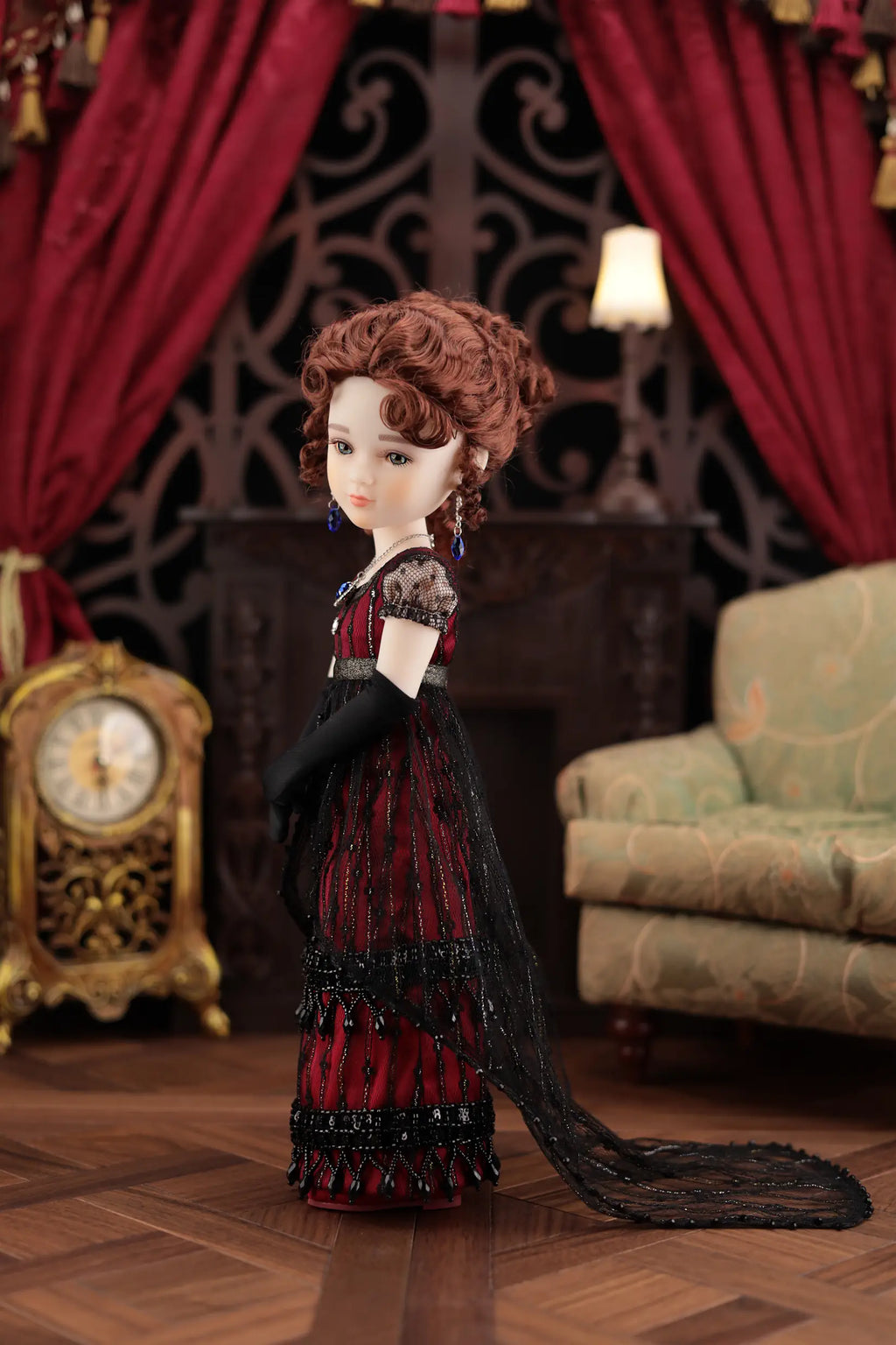 Doll in a red dress with black gloves in a decorative room with red curtains and a clock.
