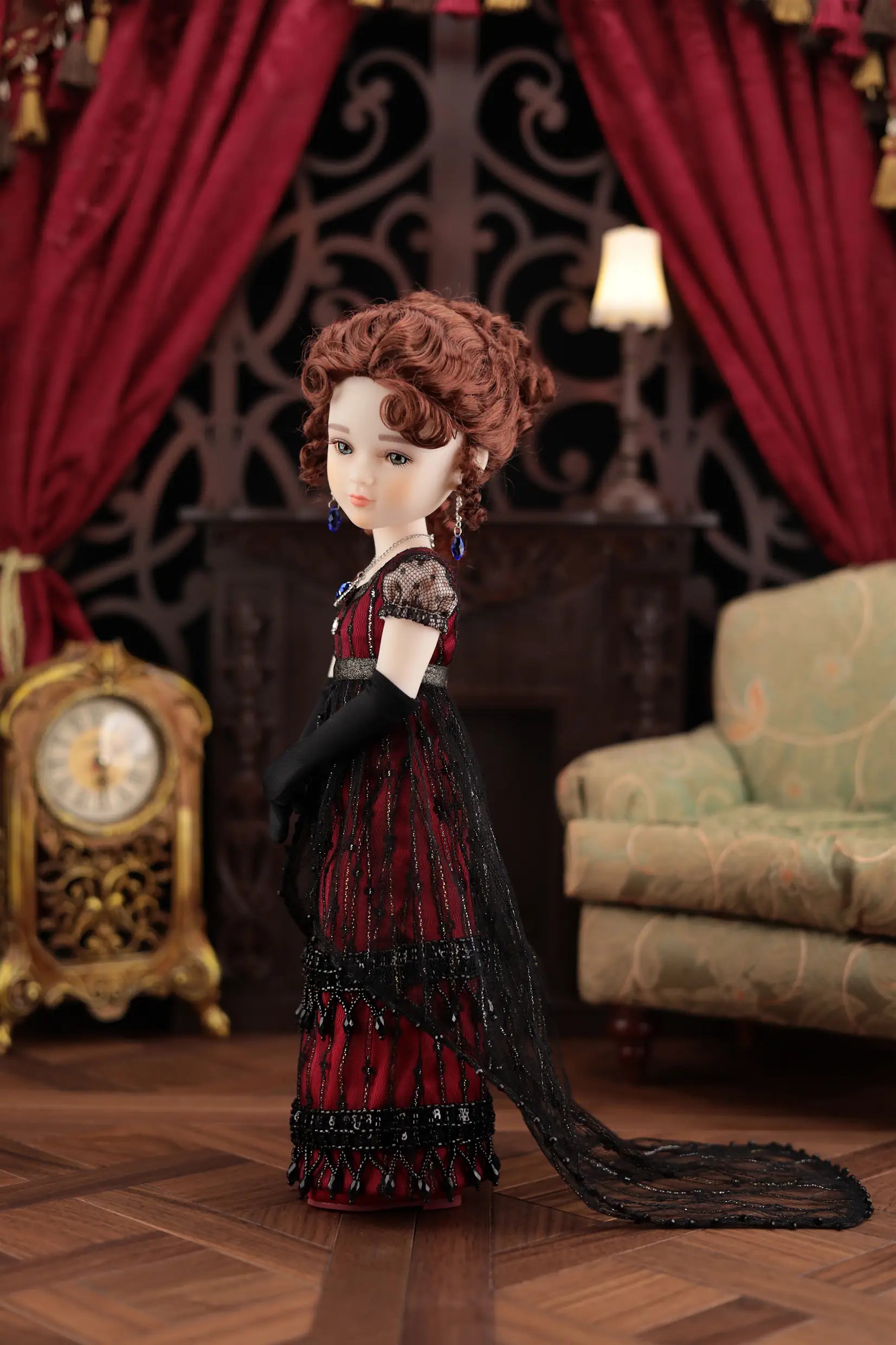 Doll in a red dress with black gloves in a decorative room with red curtains and a clock.