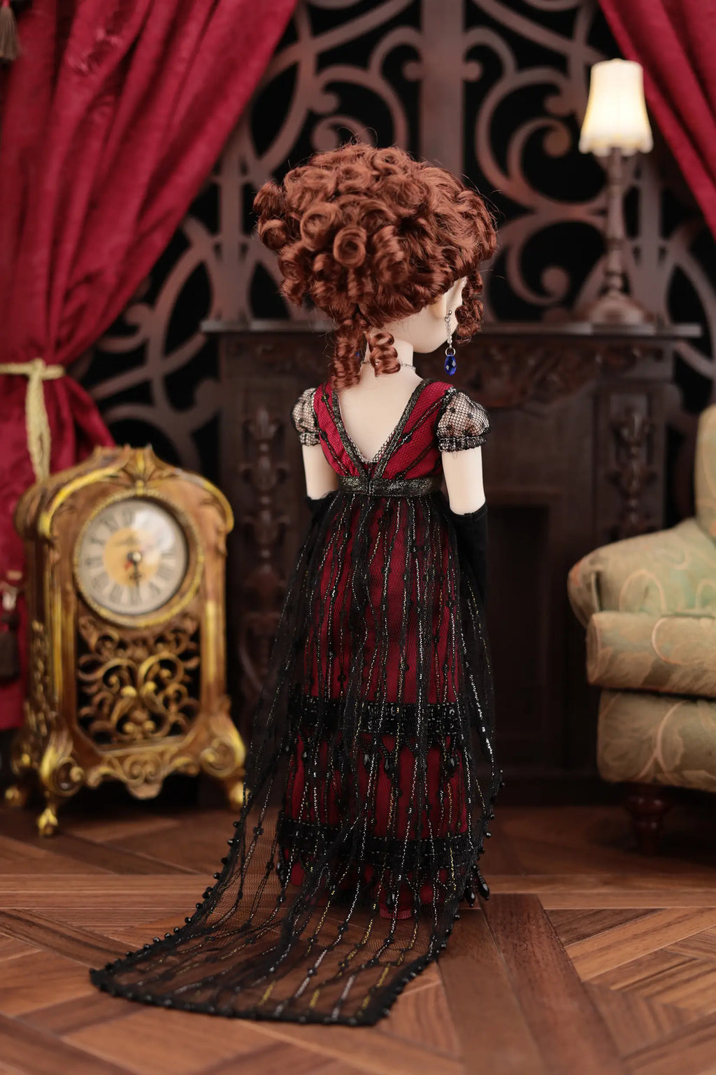 Doll in a red dress standing in a room with decorative elements.