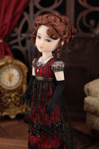 Vintage-style doll in a red dress with intricate details, standing in a decorative setting.