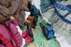 Close-up of various shoes and clothing items on a textured surface