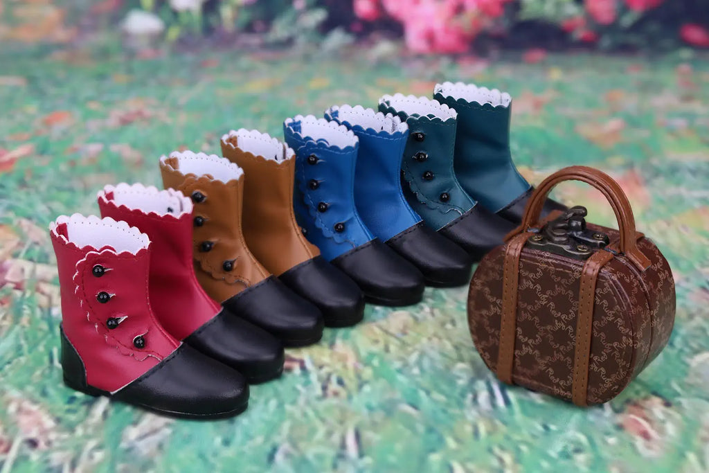 Row of colorful dog boots with a small suitcase on a textured surface