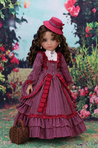 Doll in a red and white dress with a Magenta hat against a floral background