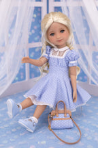 Doll in a blue polka dot dress with a matching handbag on a blue polka dot background