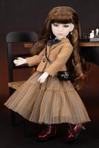 Doll in a brown coat and dress sitting on a chair with a dark background