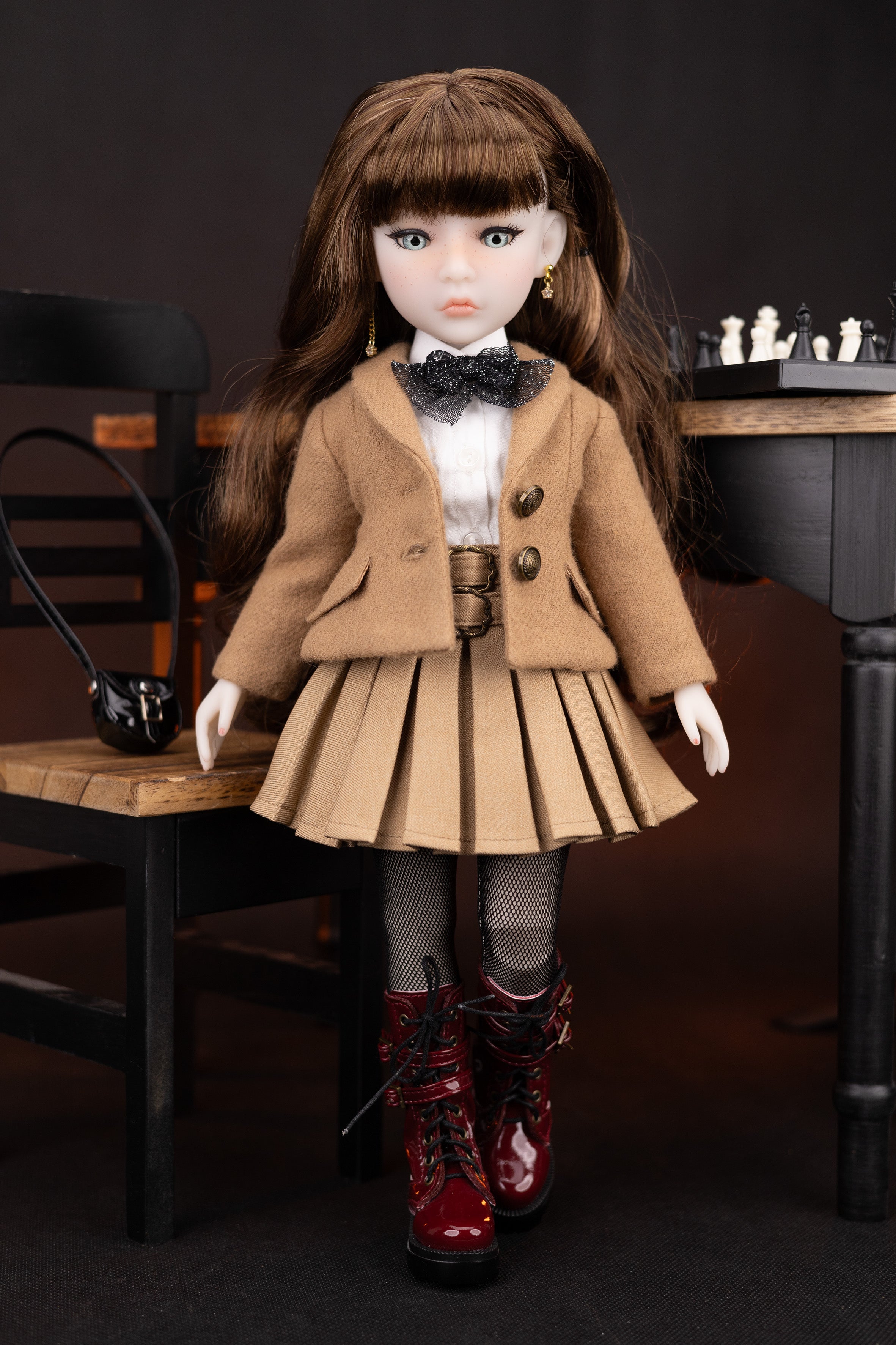 Doll in a brown coat and skirt with red boots on a dark background