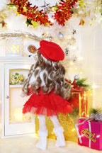 Decorative scene with a doll in a red outfit, surrounded by Christmas decorations and lights.