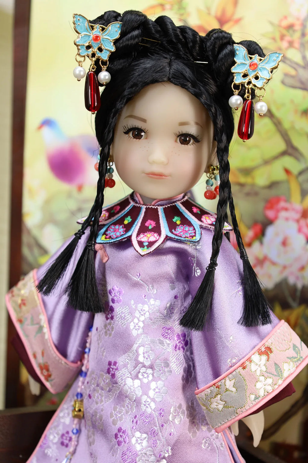 Traditional Chinese doll with intricate hair accessories and clothing against a floral background