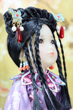 Close-up of a doll with traditional hairstyle and accessories against a blurred background