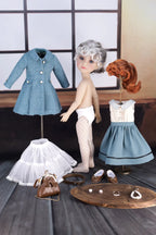 Doll with clothing items on a wooden surface