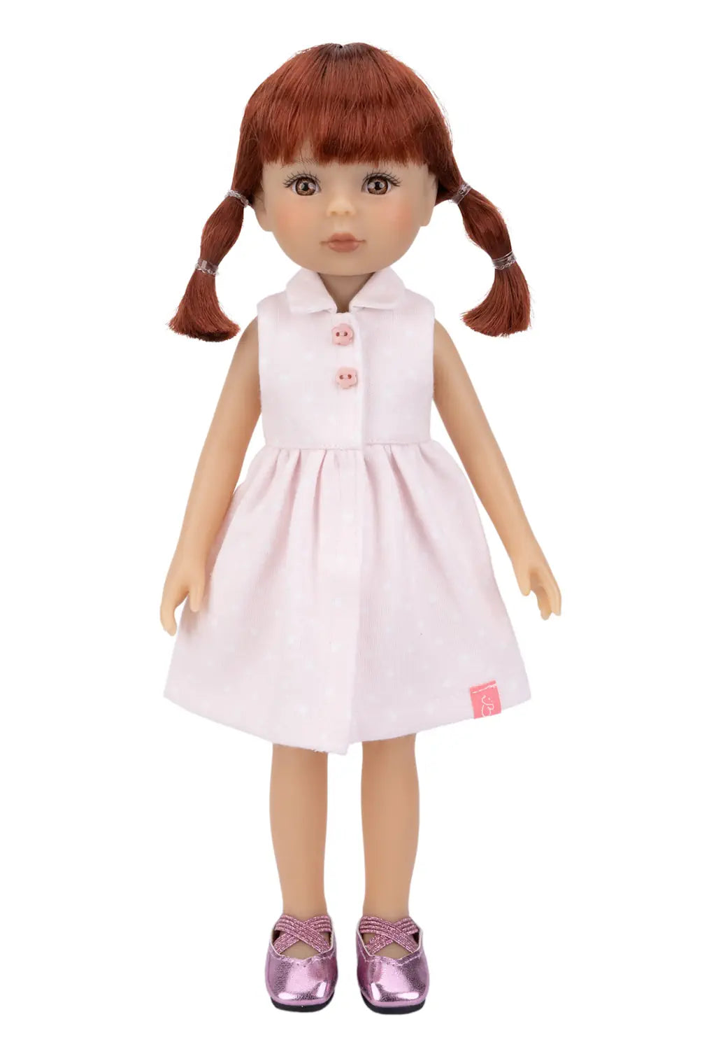Doll with red hair in pigtails wearing a white dress on a white background