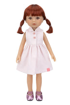 Doll with red hair in pigtails wearing a white dress on a white background