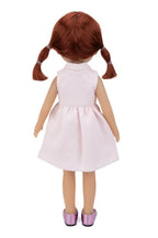Doll with red hair in pigtails wearing a white dress on a white background