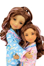 Two dolls in pajamas with a white background