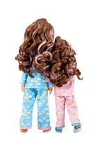 Two dolls wearing pajamas with cloud and star patterns on a white background