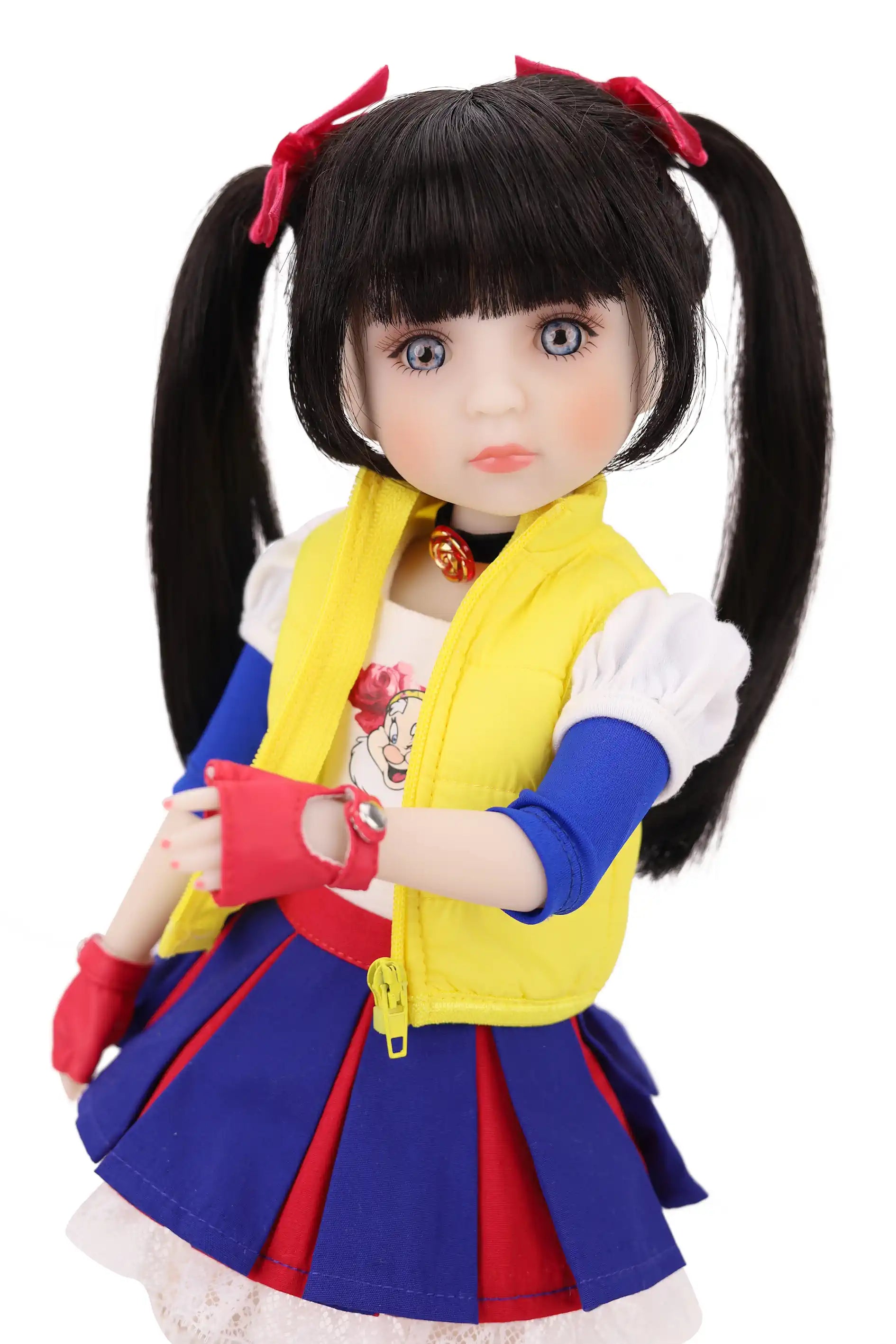 Doll with long black hair styled in pigtails, wearing a colorful outfit with a yellow vest, blue skirt on a white background.