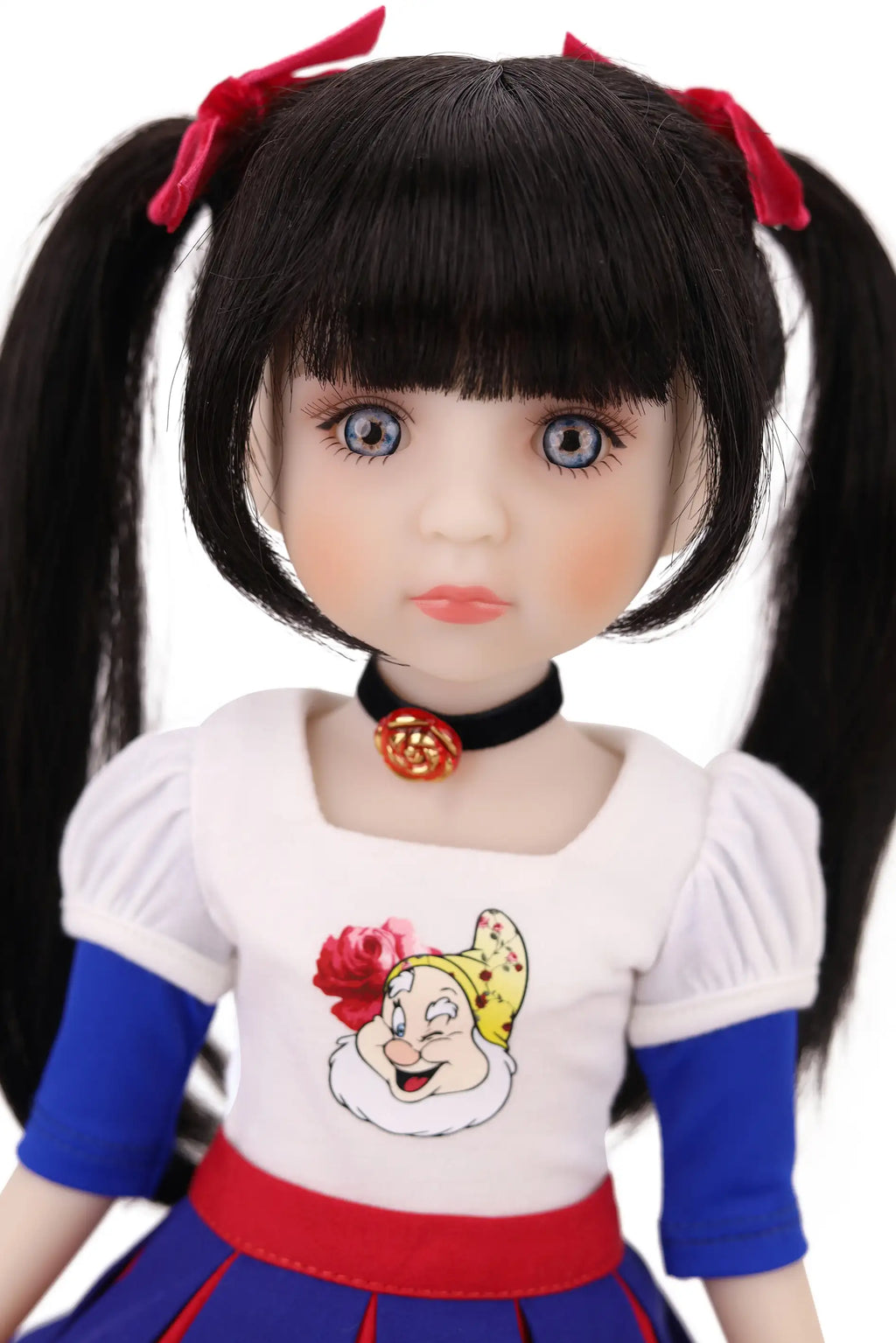 Doll with black hair styled in pigtails, wearing a white shirt with a cartoon character.