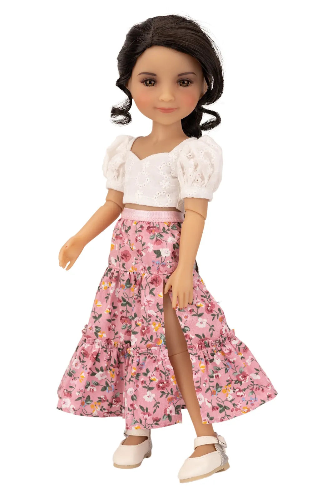 Doll wearing a white top and pink floral skirt on a white background