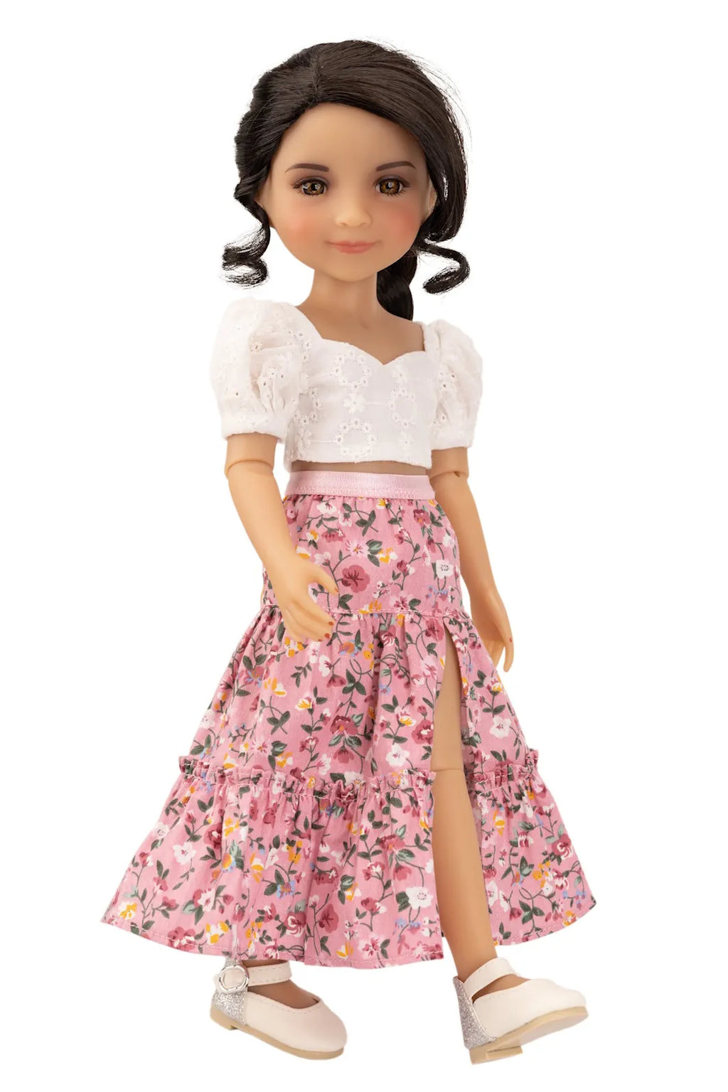 Doll wearing a white top and pink floral skirt on a white background