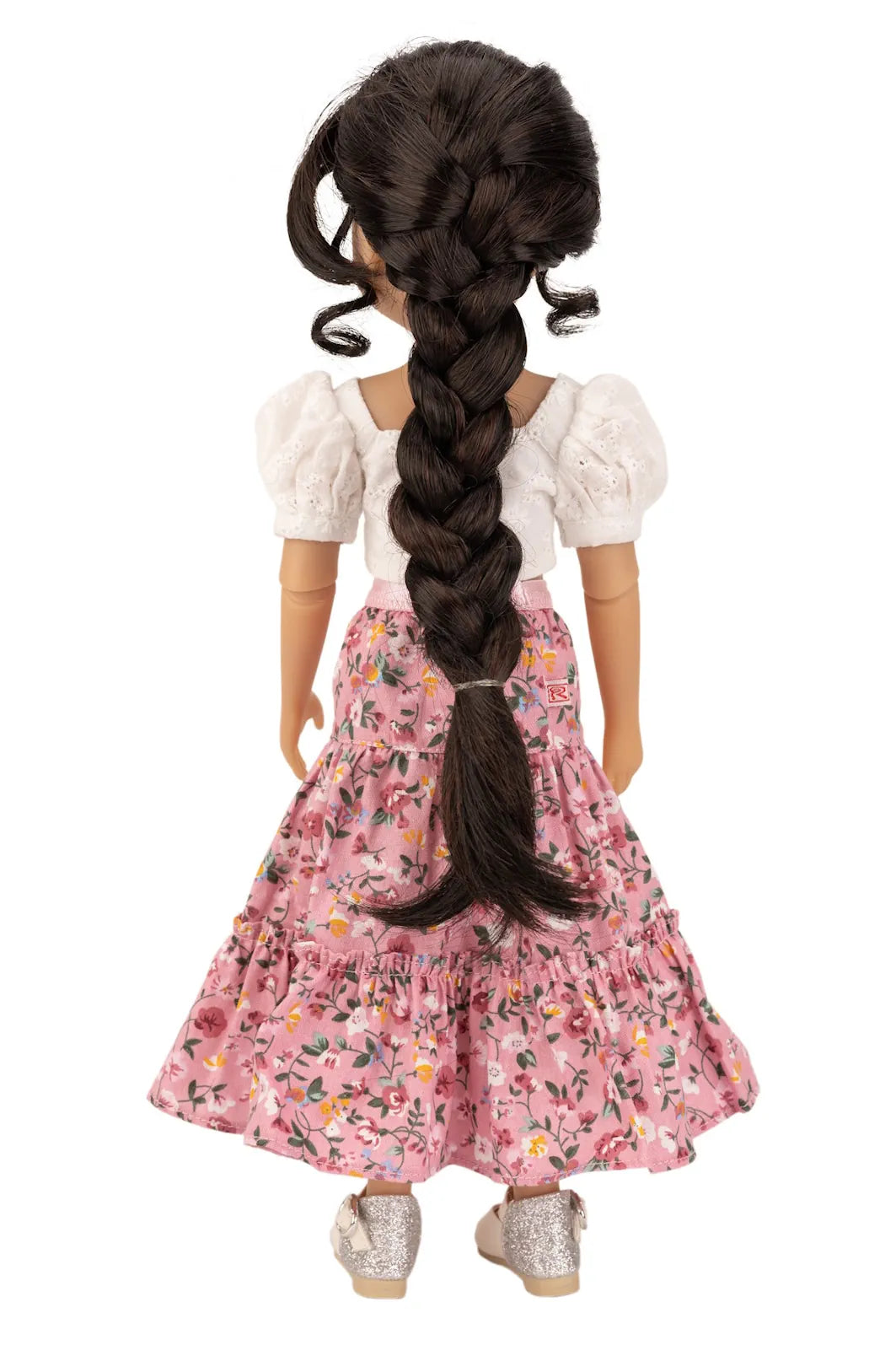 Doll with long braided hair wearing a floral dress on a white background