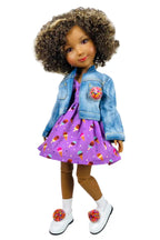 Doll wearing a denim jacket and purple dress with ice cream pattern on a white background