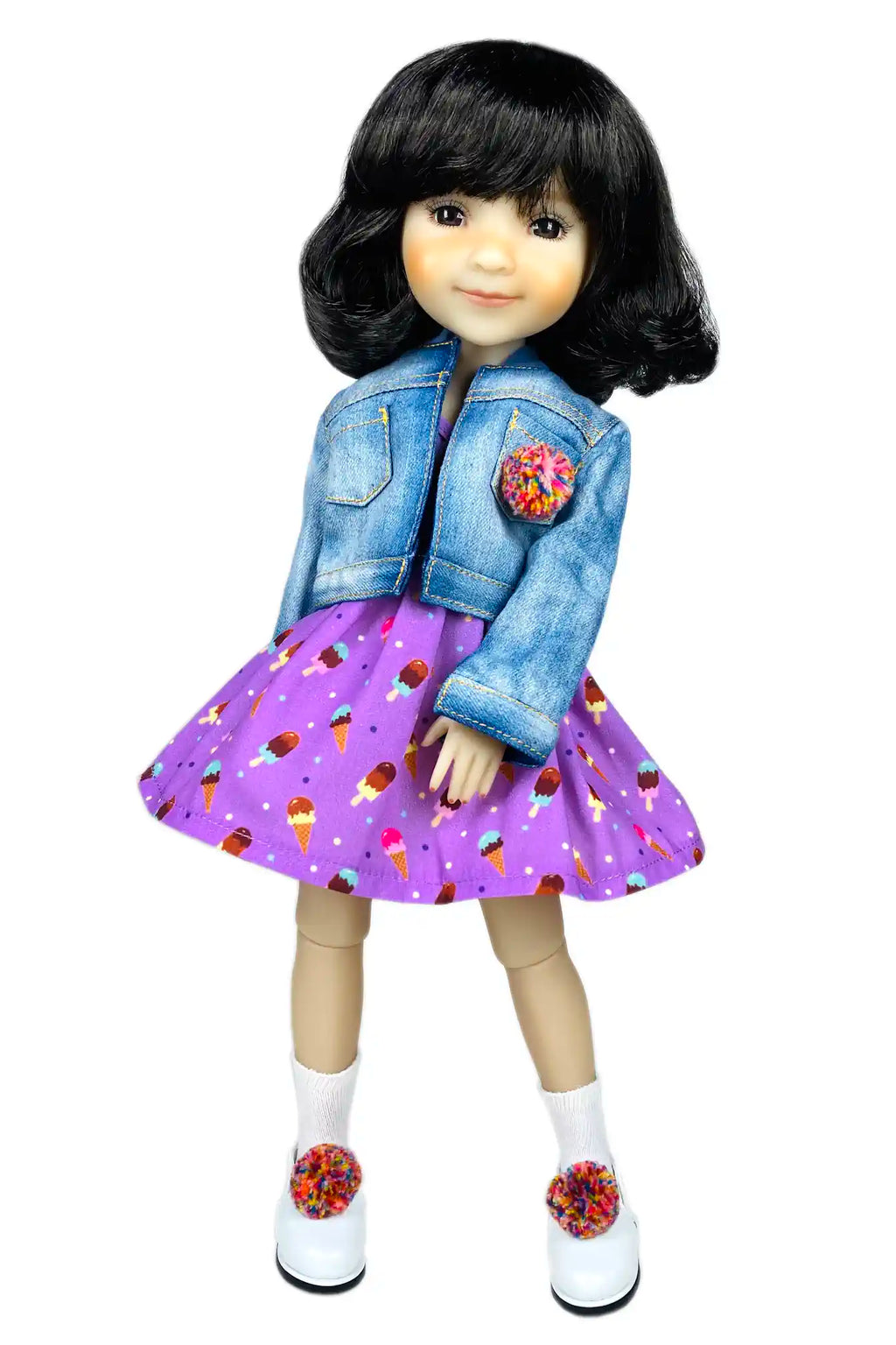 Doll wearing a denim jacket and purple dress with ice cream pattern on a white background