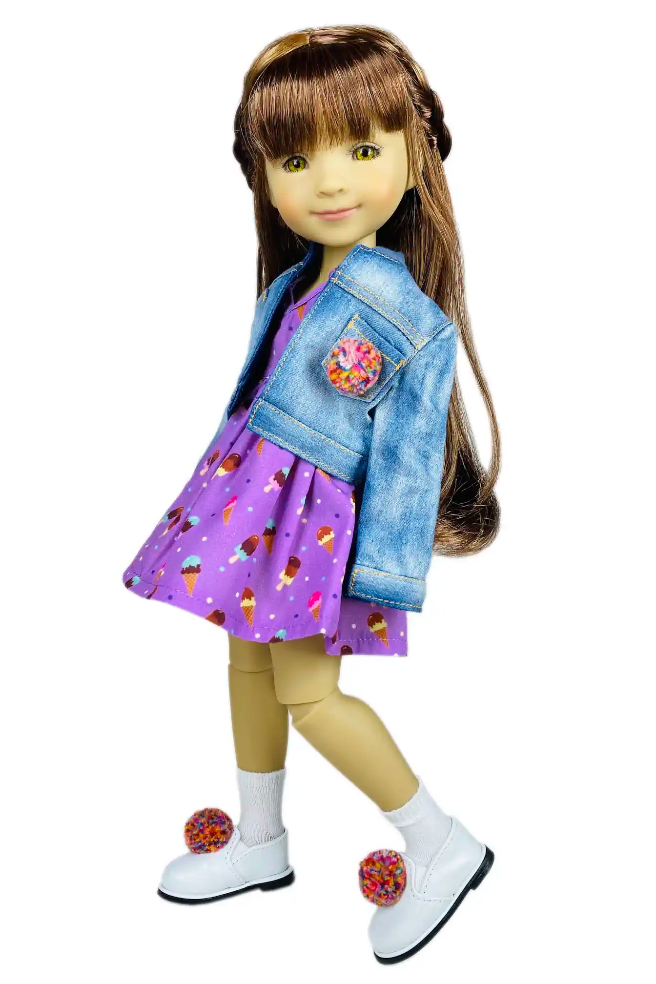 Doll wearing a denim jacket over a purple dress with ice cream pattern on a white background