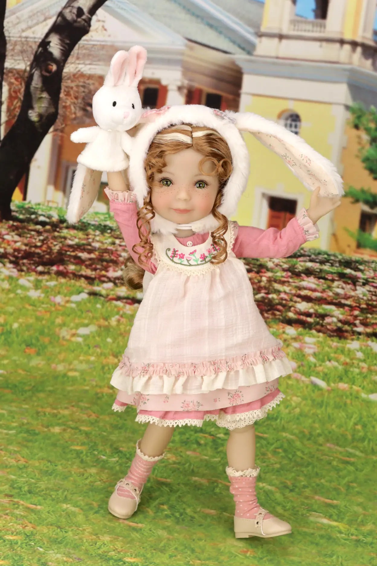 Doll in a pink dress holding a white rabbit toy outdoors.