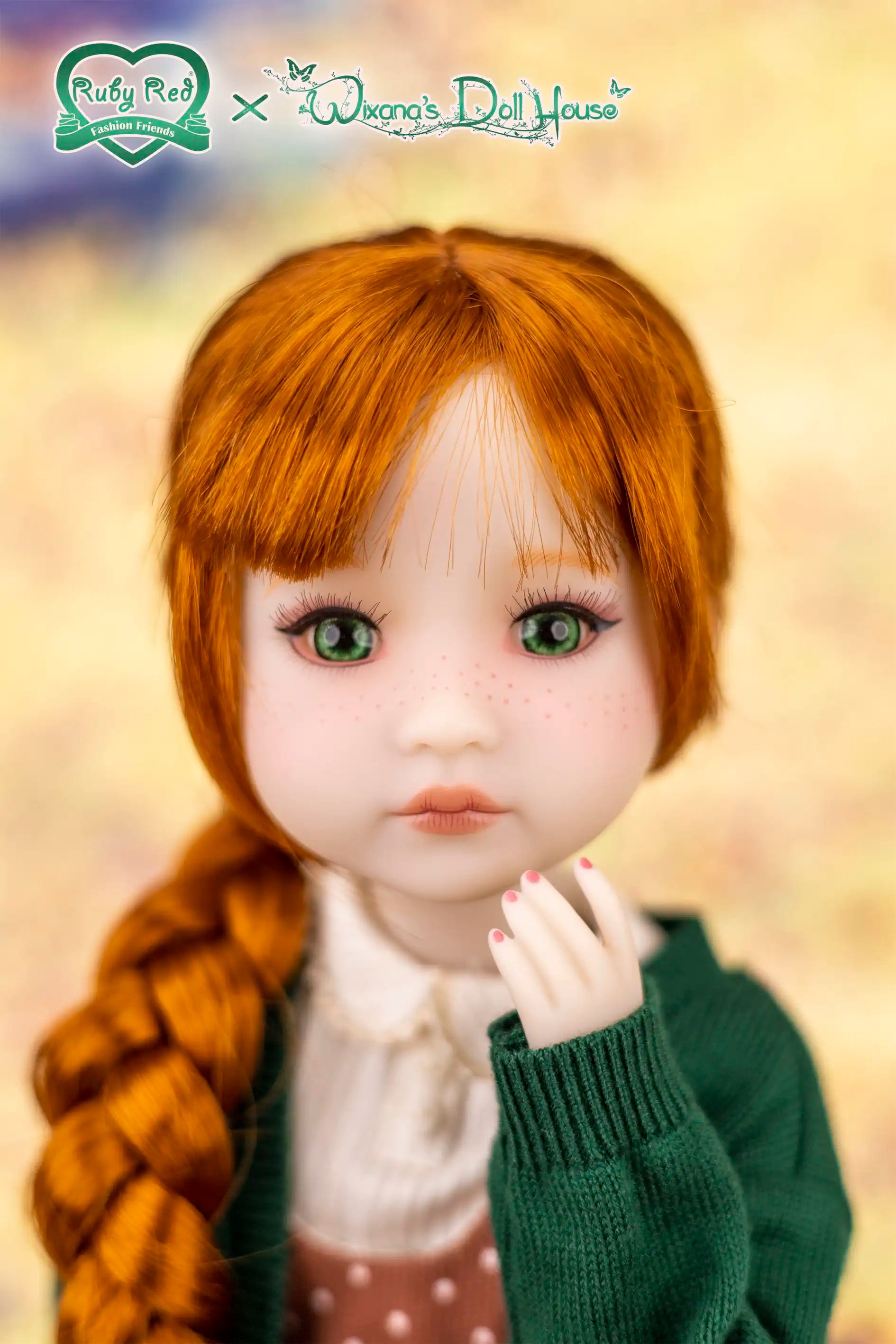 Doll with red hair and green eyes wearing a green outfit against a blurred background