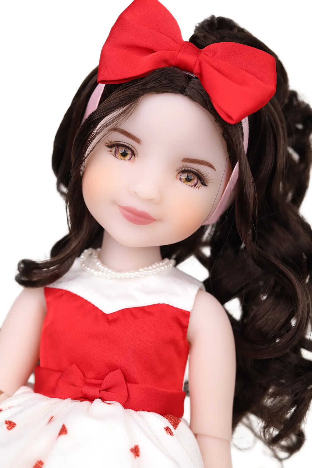 Doll with red hair bow and red and white outfit on a white background