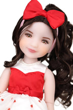 Doll with red hair bow and red and white outfit on a white background