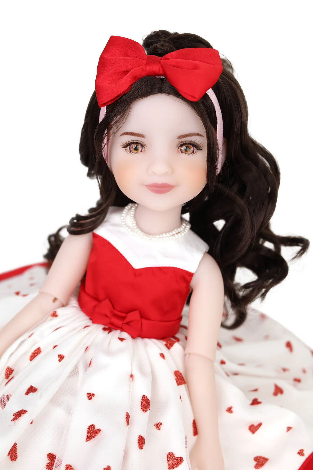 Doll with red bow and red and white dress on a white background
