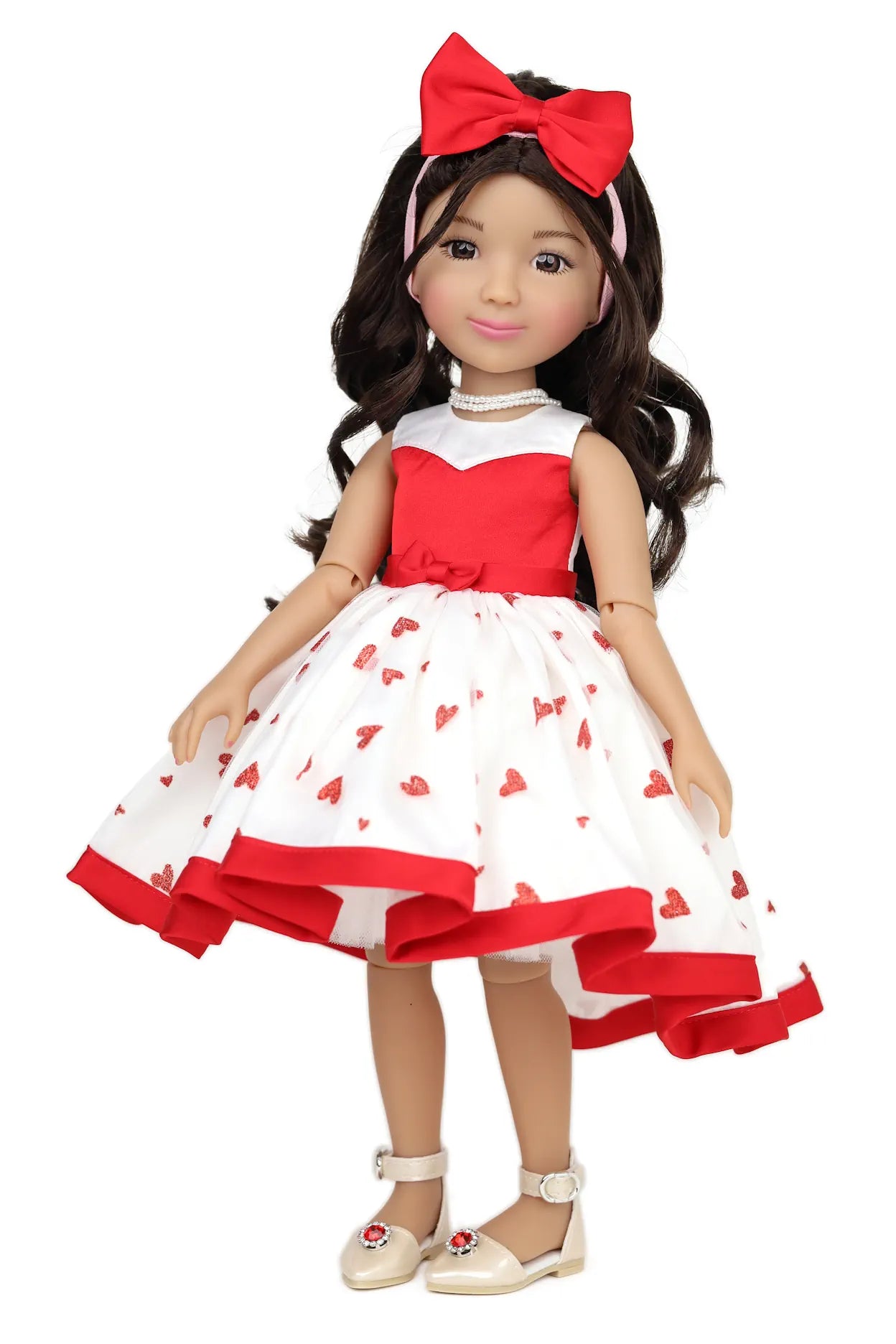 Doll wearing a red and white dress with a heart pattern on a white background