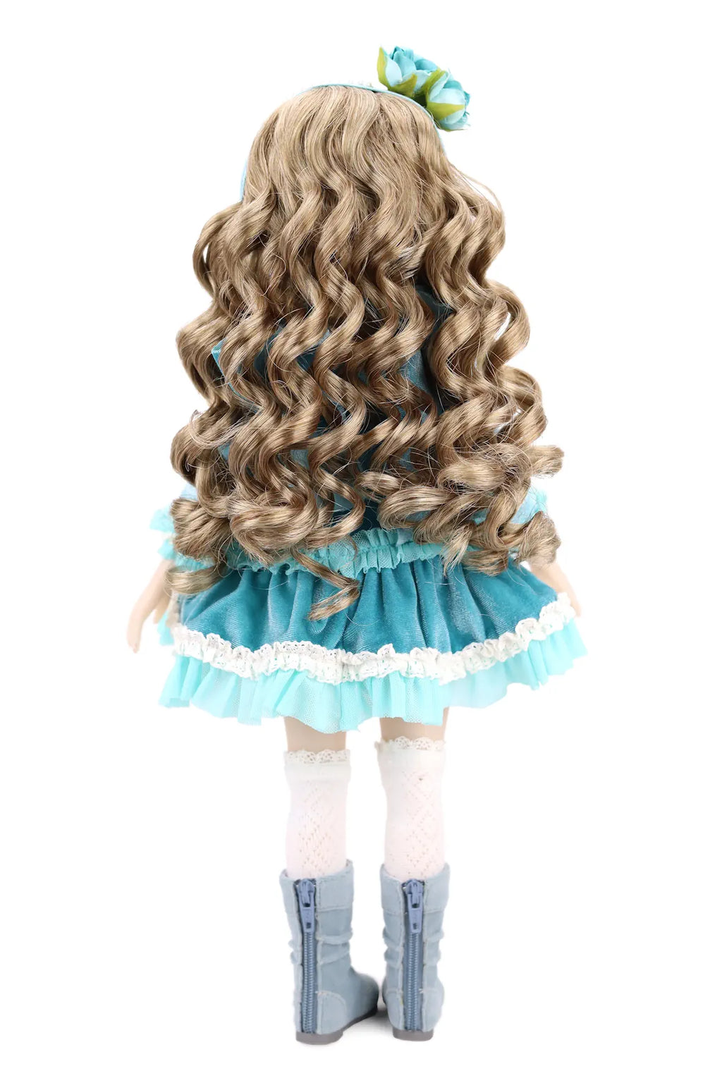 Back view of a doll with long wavy hair, wearing a blue dress and white stockings on a white background.