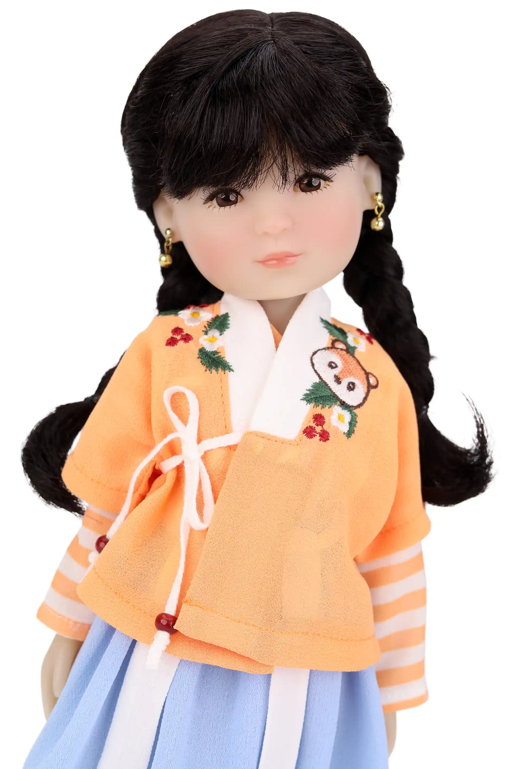 Doll wearing a traditional outfit with an orange top and blue skirt on a white background