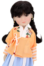 Doll wearing a traditional outfit with an orange top and blue skirt on a white background