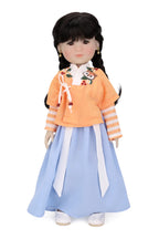 Doll wearing a traditional outfit with an orange top and blue skirt on a white background
