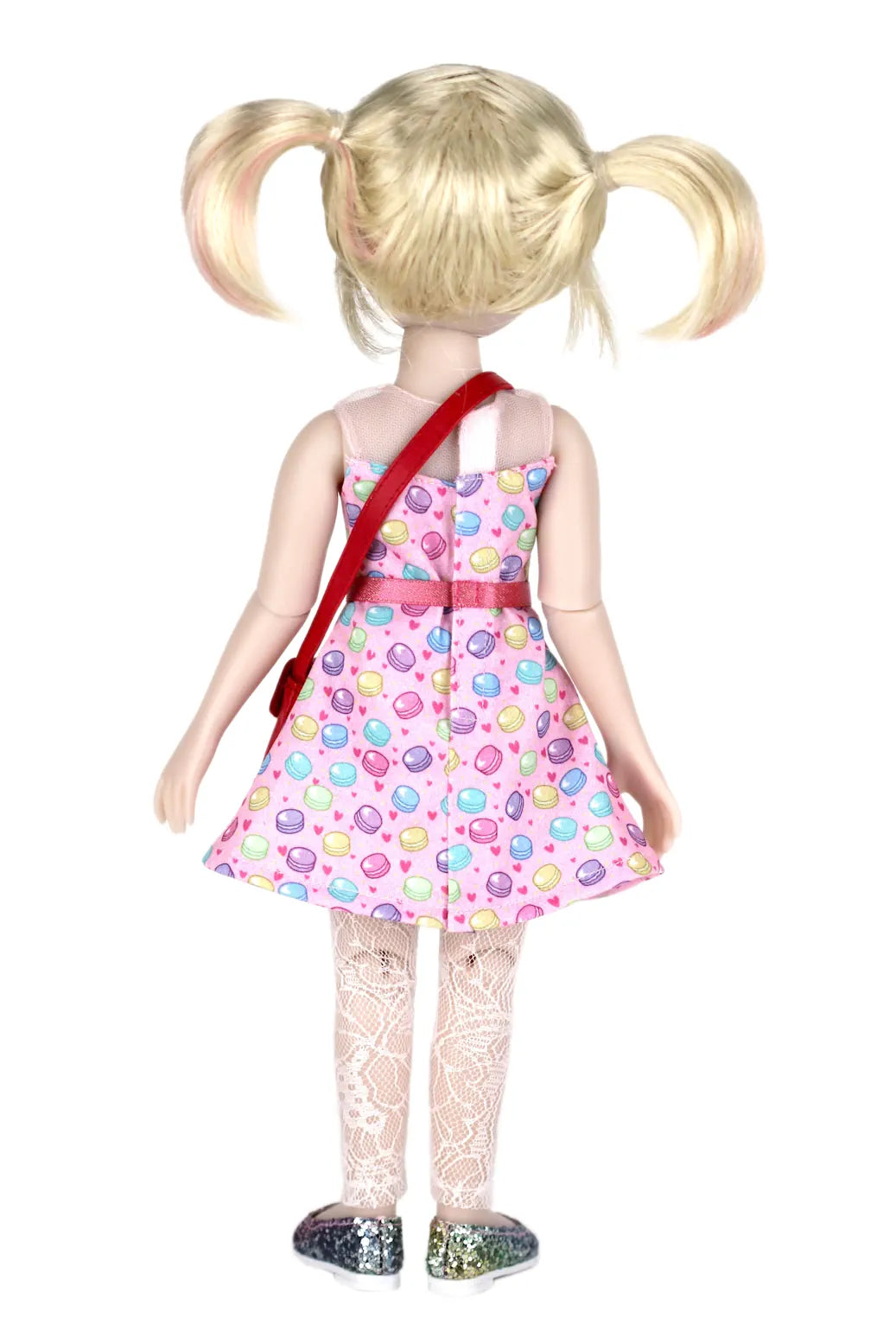 Callie with blonde pigtails wearing a colorful dress and red bag on a white background
