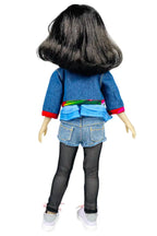 Hanna wearing a denim outfit with a colorful belt on a white background