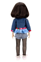Doll wearing a denim outfit with a colorful belt on a white background