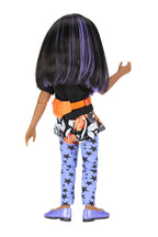Kelsey with black and purple hair wearing a colorful outfit on a white background