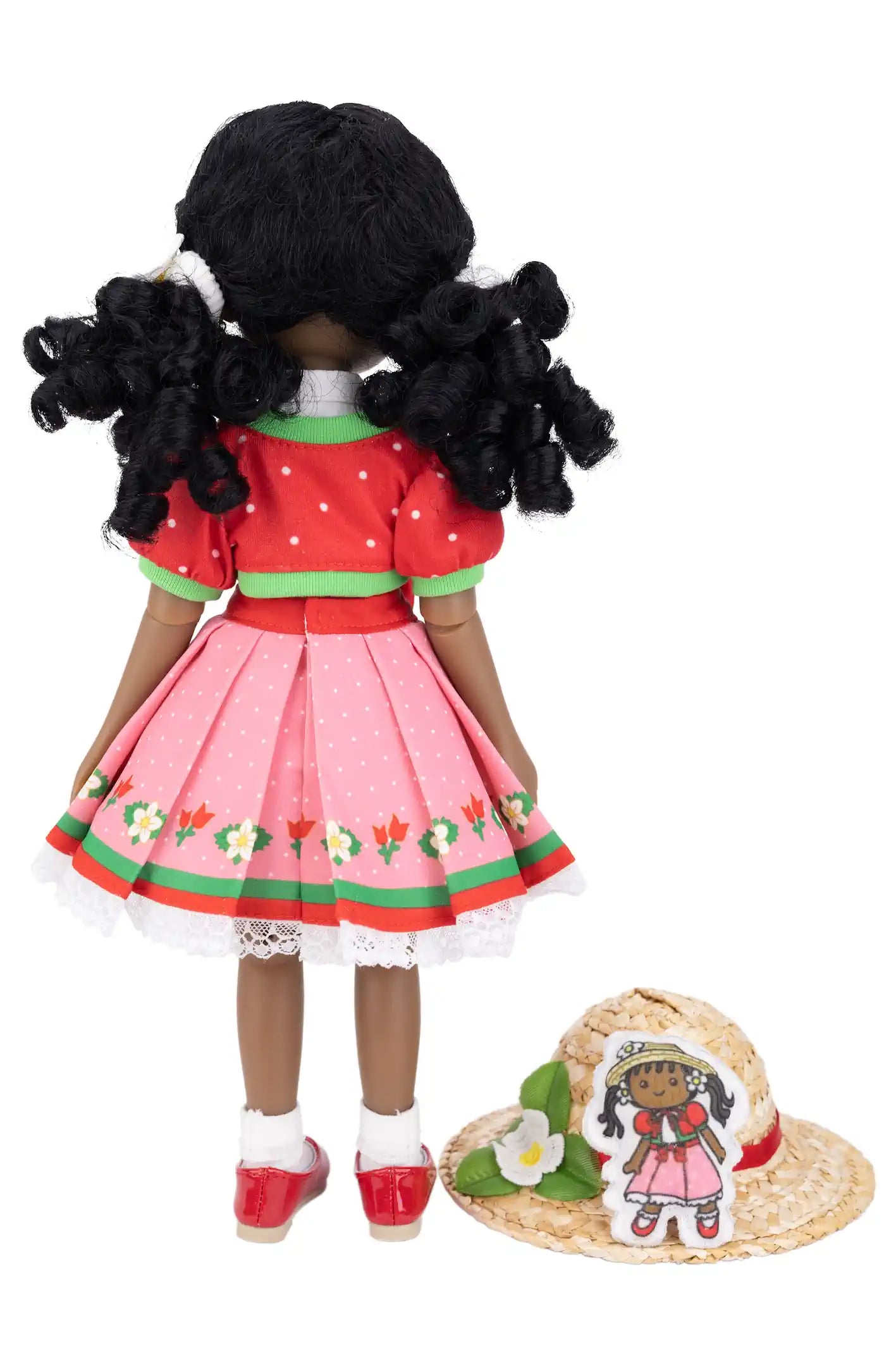Kyra with a red and pink dress and straw hat on a white background