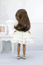 Ruth with long brown hair wearing a white dress and shoes on a light background