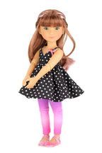 Bailey wearing a black polka dot dress with pink leggings on a white background