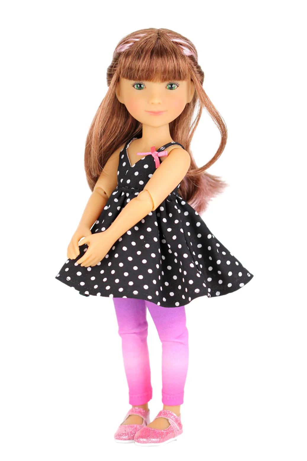 Bailey wearing a black polka dot dress with pink leggings on a white background