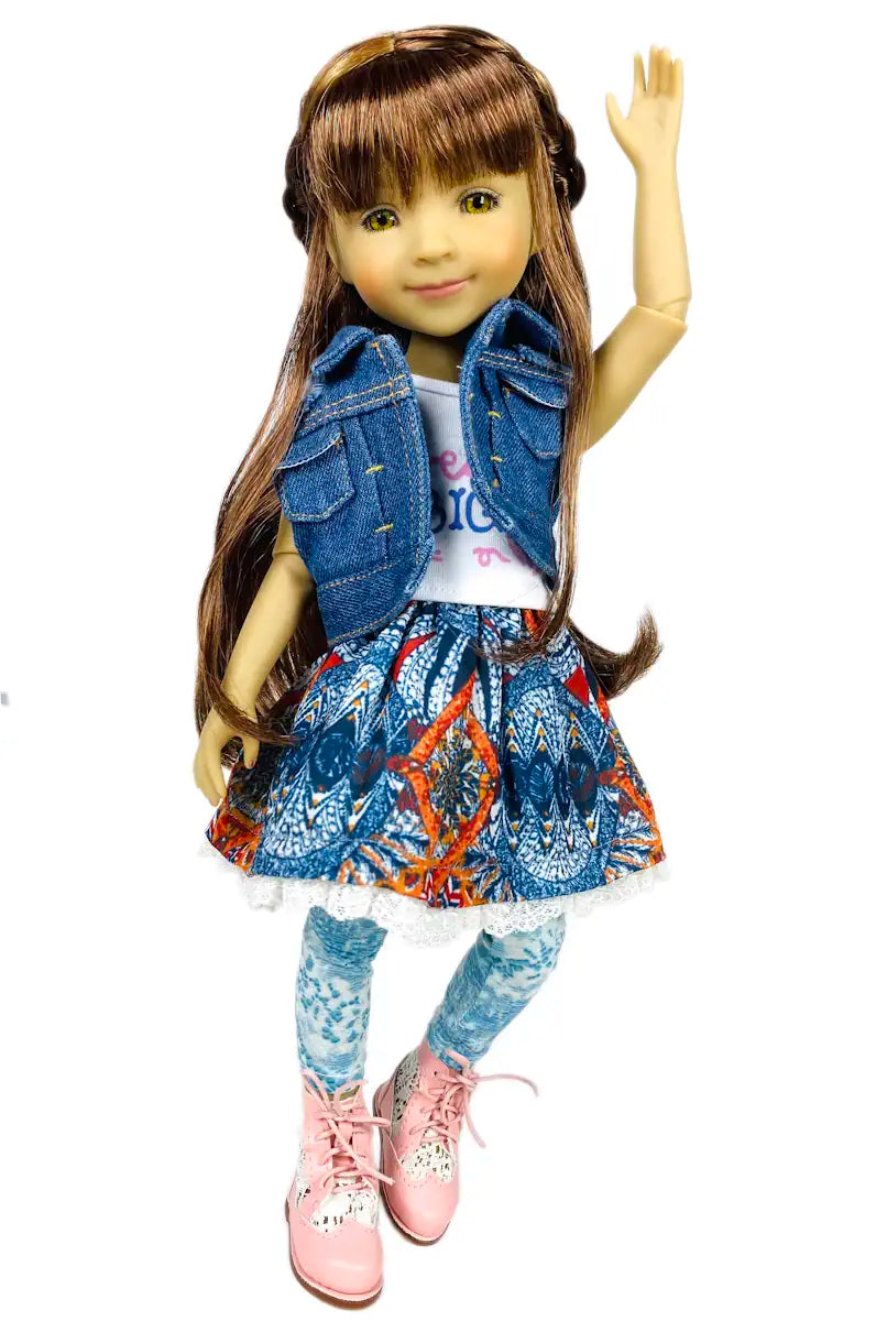 Bella wearing a denim jacket, colorful skirt, and pink shoes on a white background