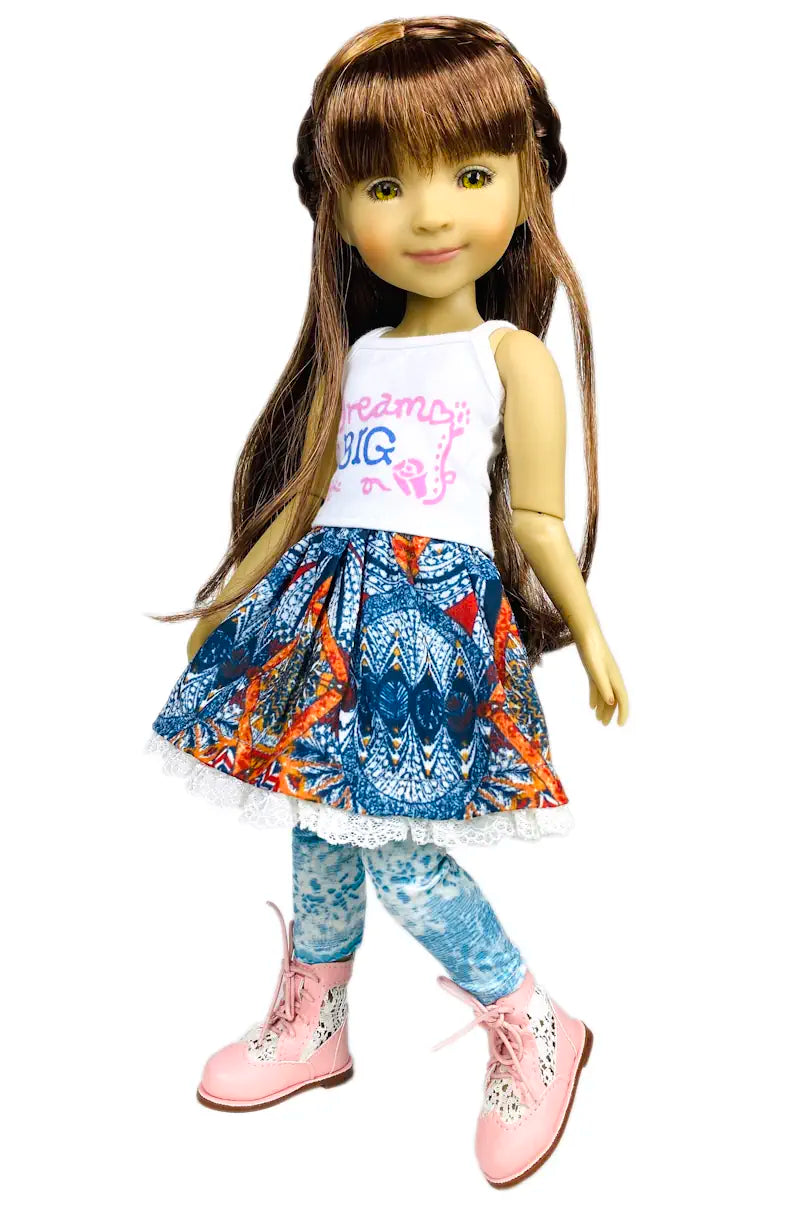 Bella wearing a white tank top with text and a blue patterned skirt on a white background