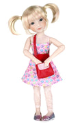 Callie with blonde pigtails wearing a colorful dress and red purse on a white background