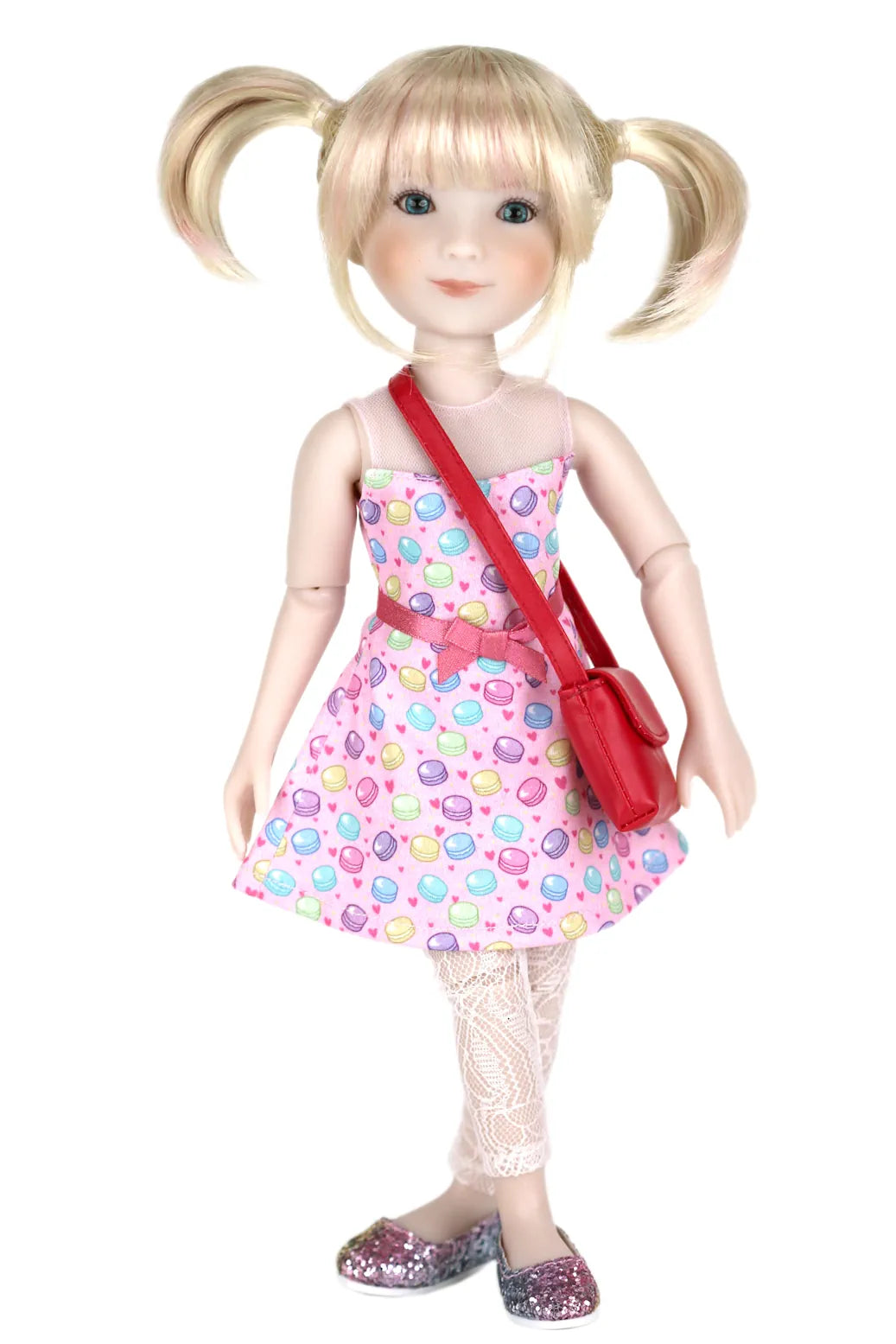 Callie with blonde hair styled in pigtails, wearing a colorful dress and red bag on a white background