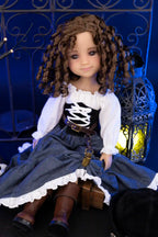 Clark with curly hair wearing a white blouse and blue skirt in front of a decorative metal gate.